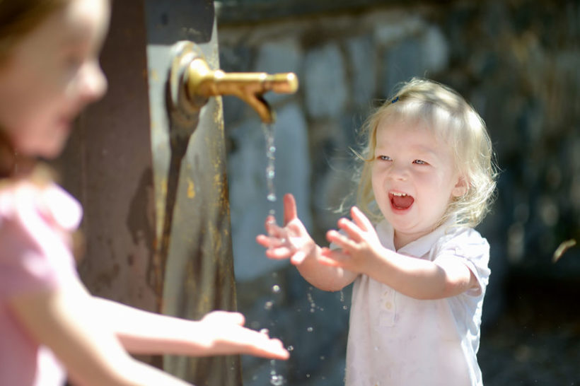 40946753 - two sisters having fun with drinking water fountain in italy