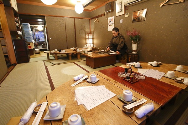 ↑串駒の二階。暖色の灯かりが穏やかに店内を照らす。手前のテーブルは、日本酒のタンクのフタを貰い受け、再利用したもの