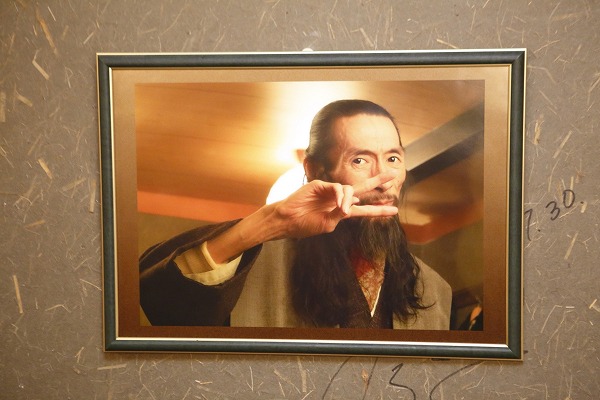 ↑壁に掲げられた大林 禎さんの遺影。長髪に長いあごヒゲ、謎のピースサインと、一見してただものではないのがわかる