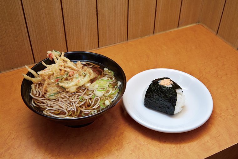 ↑かき揚げそば+おにぎり鮭(360円+125円)。つゆを吸ってほぐれる衣と野菜の味わいが絶妙。おにぎりと一緒に味わえばうまさ倍増だ