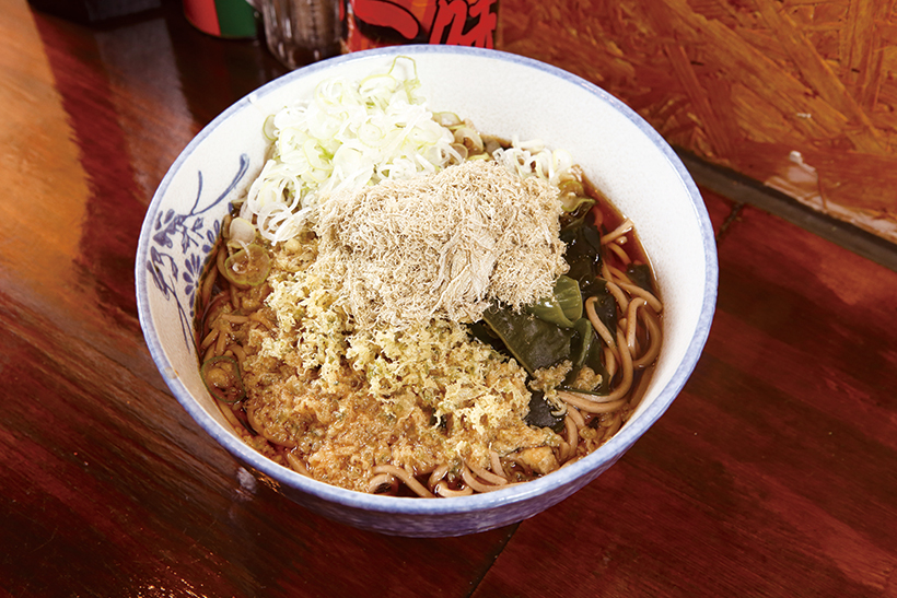 ↑門仲そば(420円)。おぼろ昆布と天かす、わかめをトッピング。ゆで麺につゆ、おぼろ、天かすが絡みつき、濃厚なコクのある味わいに