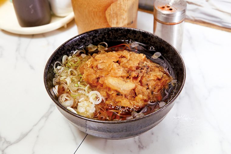 ↑げそかきそば（400円）。ぶつ切りのいかげそと玉ねぎのかき揚げがのった一品。げその食感とうまみで一気に完食できる