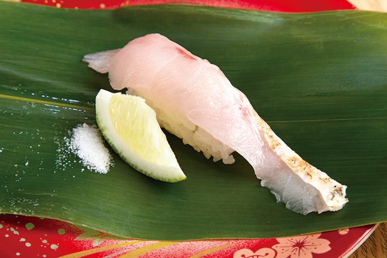 ↑のどぐろ／一貫（410円）　全国の漁港から築地に届く、鮮度抜群の高級魚「のどぐろ」を握りに。同店ではすだちと塩でいただく。濃厚な脂のうまみがすだちで引き立ち、爽やかなあと味を醸し出す