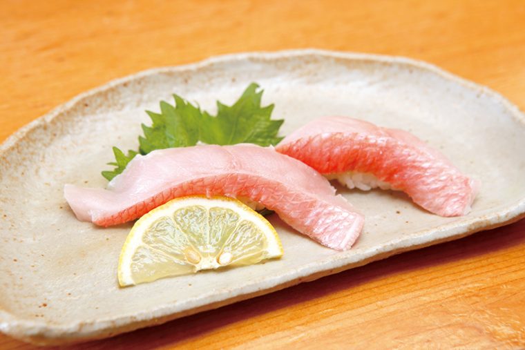 ↑地金目/二貫(518円) 肉厚で大ぶりにカットされた金目鯛は、食べ応え抜群。芳醇な脂の乗りだが、繊細な味わいも楽しめる。しょうゆは使わず、目の細かい塩とレモンで食べるのがオススメだ