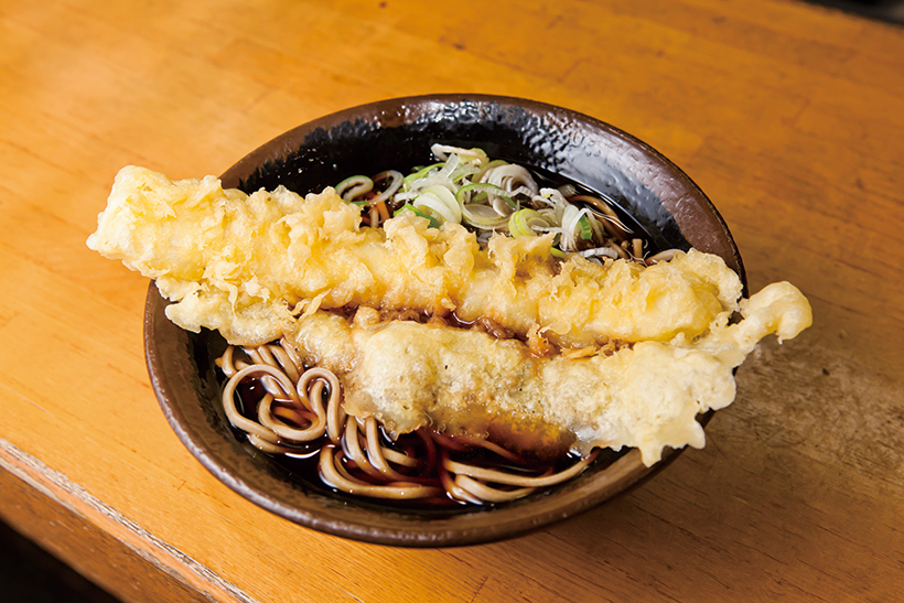 ↑いか天そば(430円)。丼からはみ出す大迫力のいか天。黒いつゆがしみた羽根も文句なし!