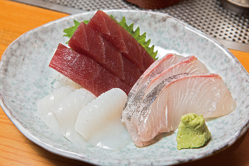 ↑刺身3点盛(900円) その日のオススメの魚を刺身三種盛りに。写真はまぐろの赤身とかんぱち、甲いかの子ども。甲いかの豊かな風味とうまみが印象的だ