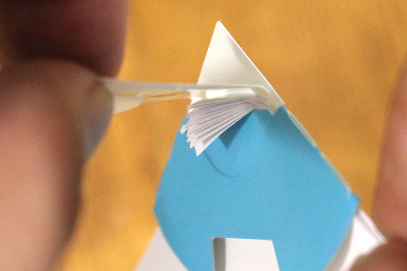 ↑紙のカドをまとめて折り込んでいる図