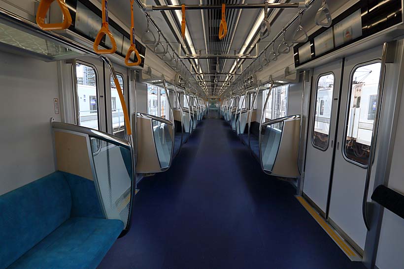 ↑13000系の車内。座席はロングシート。照明は眩し過ぎず、ほど良い明るさを目指している