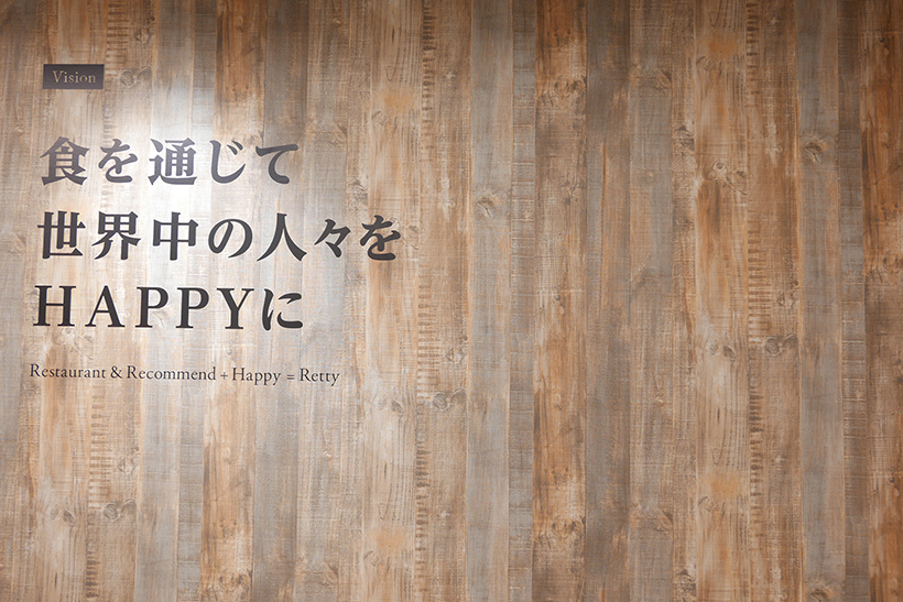 ↑オフィス入り口に掲げられた標語「食を通じて世界中の人々をHAPPYに」