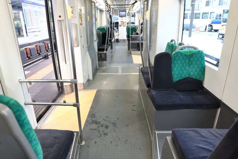 ↑車内はセミクロスシートで通路も広く造られている。通勤通学に利用する乗客も多い