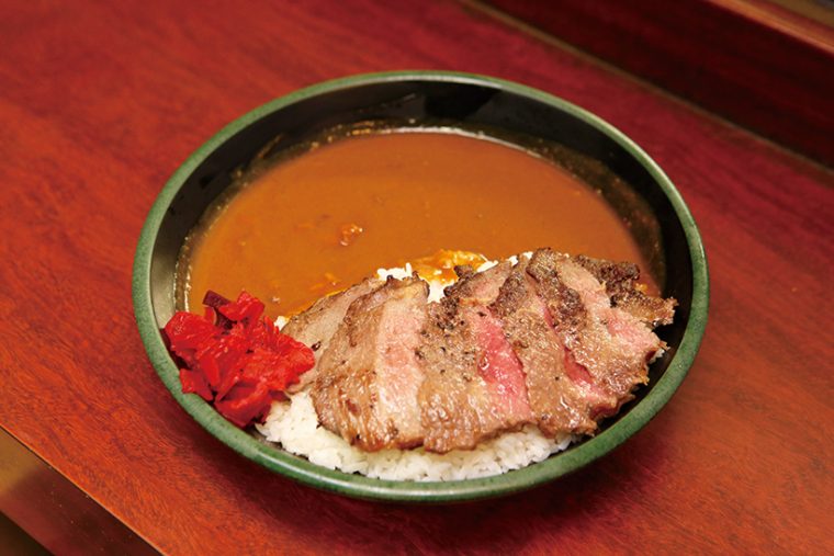 「ステーキカレー」はミディアムレアに焼いた牛肉をカレーにトッピング。ジュー シーな牛肉と、あとからくるルーの辛さのマッチングが見事だ。通常1100 円を火木土日は690 円で提供