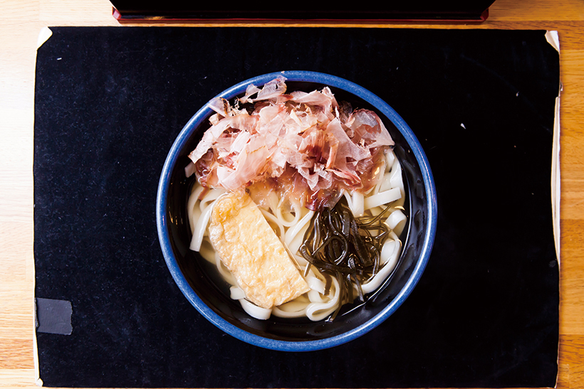 ↑きしめん（380円）　油揚げ、刻み昆布、花かつ おが飾られた看板メニュー。 揚げの風味が残る油揚げはほどよい甘さで、刻み昆布の食感が心地いい
