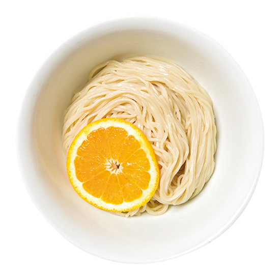 ↑夜鳴きつけそば(880円) 麺皿にはオレンジが大胆に置かれ、麺を持ち上げるとほのかに柑橘香が漂う。つけ汁の出汁は鶏と魚介がベースのすっきり系だ
