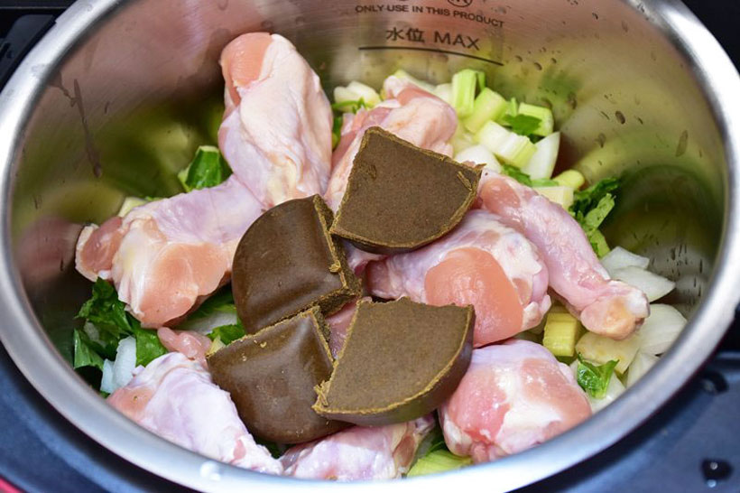 ↑トマト、タマネギ、セロリの上に鶏の手羽元、カレールウを入れたところ。トマトは見えていないが、3個しっかりと入っている