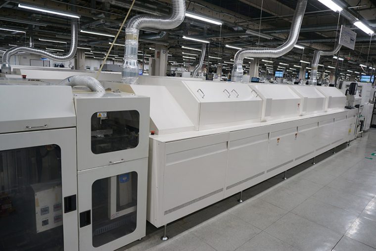 ↑こちらは基板にコンデンサなどの部品をハンダ付けするリフロー炉という機械。ハンダが焼けるニオイがします