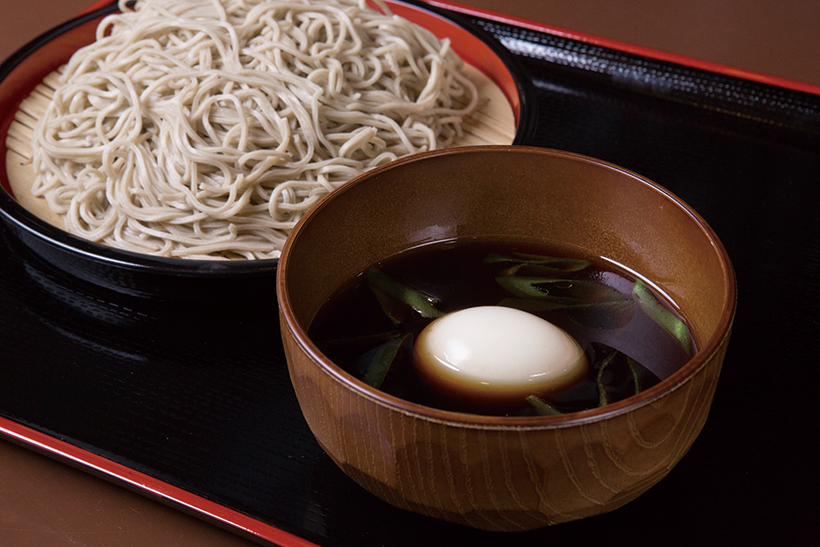 ↑ネギたま蕎麦（穂のか蕎麦・並盛）（600円）。ネギ油とスパイスがそばつゆに新たなうまみを加え る。玉子のとろりとした黄身を絡めるとさらに美味。ぜ ひ試してほしいメニュー