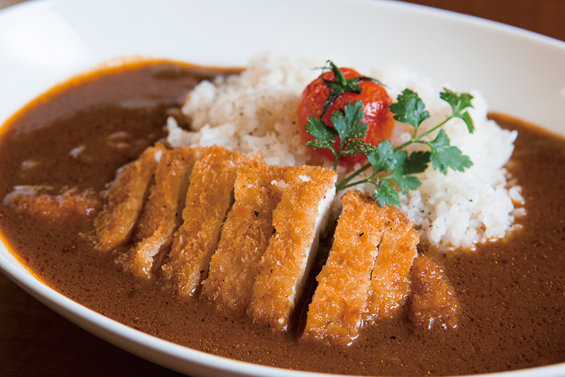 ↑チキンカツカレー(500円)。鶏の手羽元とかつお節で取ったス ープ、複数のスパイスを使い、1日煮 込んで1日寝かせた。カツは衣サクサ クで肉は柔らかい。素揚げしたプチ トマトが彩りのアクセントに