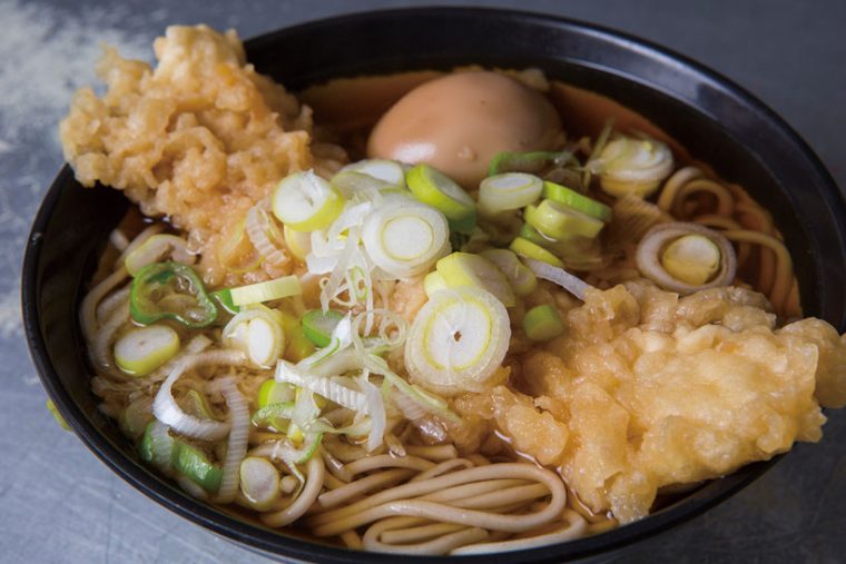 ↑いか天そば+味玉子(390円+50円)。いか天はすっと噛み切れる柔らか さ。写真では、つゆのうまみが中ま でしみた味玉をトッピングした。1日 約40個限定の人気の一品だ