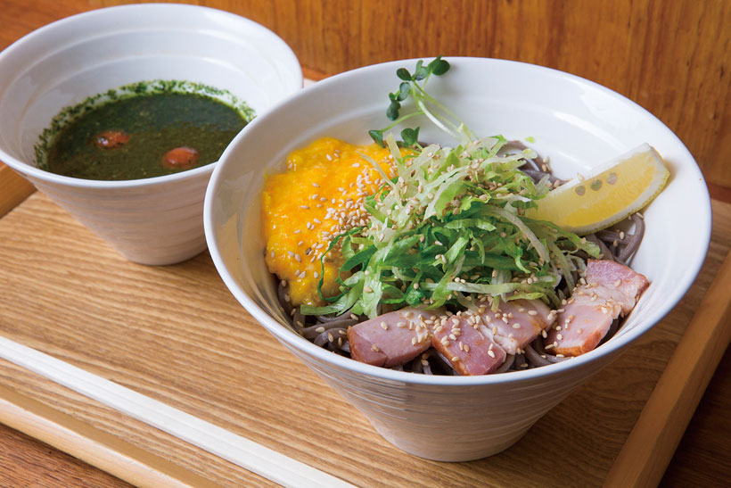 ↑バジル冷そば(850円)。バジル香るつけ汁で食べるそ ばが絶品。付け合わせにベー コンやスクランブルエッグな どが入り、味の変化も楽しい
