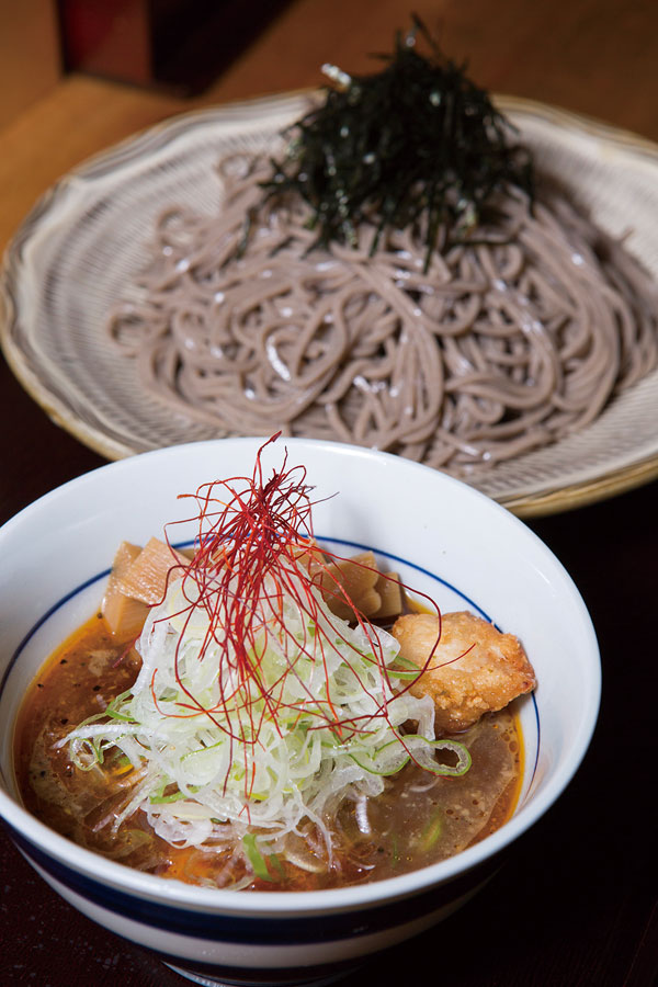 ↑鶏つけ蕎麦(大盛り)(880円)。濃厚なうまみがある つゆの中には、薄く衣を 付けて揚げたジューシー な鶏肉が入っている。50 円増しで大盛り(500g)に