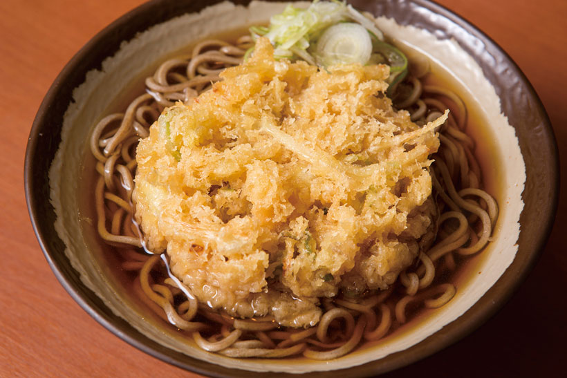 ↑天ぷらそば(350円)。玉ねぎと青ねぎを使ったシンプルなかき揚げをトッピ ング。玉ねぎの甘みと衣のコクで、つゆがさらにうまく なる