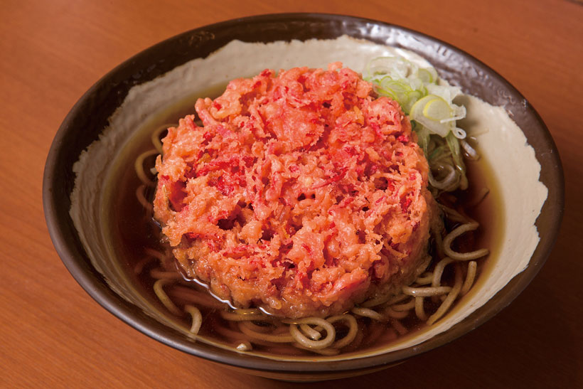 ↑紅しょうが天そば(350円)。真っ赤な色がインパクト大! 紅しょう がの強烈な酸味でつゆが甘く感じるほ どで、やみつきになる人も多い