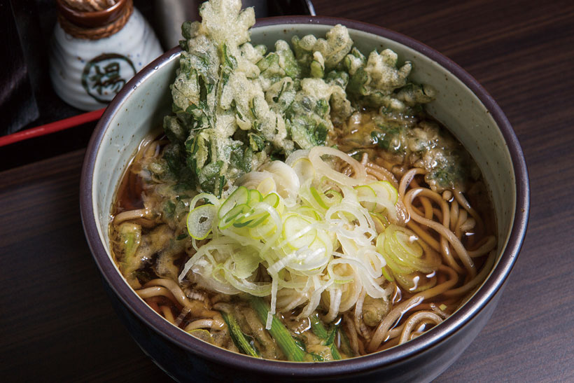 ↑春菊天そば(340円)。春菊天は衣少なめ。つゆにひたしてほぐしながら食べ ると、春菊の爽やかな香りが口いっぱいに広がる