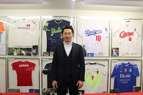 ↑牧野講平さん。背後には担当する多くのアスリートのサインが