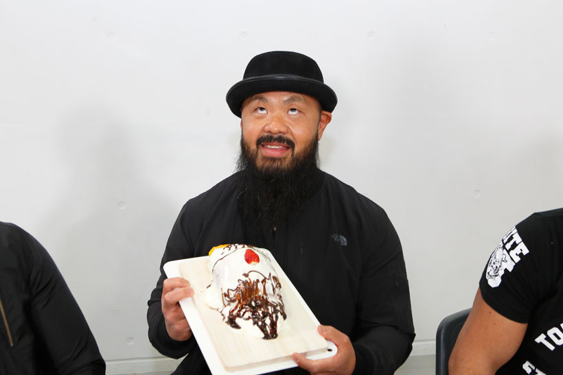 ↑「俺が食われるってことか!」と毒づきながらも、似顔絵ケーキを手におどけて見せる外道選手