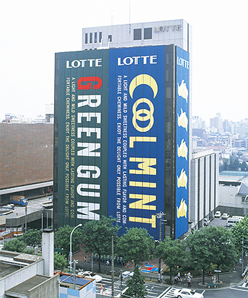 ↑1993年には、ロッテ本社ビルを「グリーンガム」「クールミントガム」のパッケージでラッピング。通常のガムサイズに換算すると、約3億個分のサイズに拡大されたという