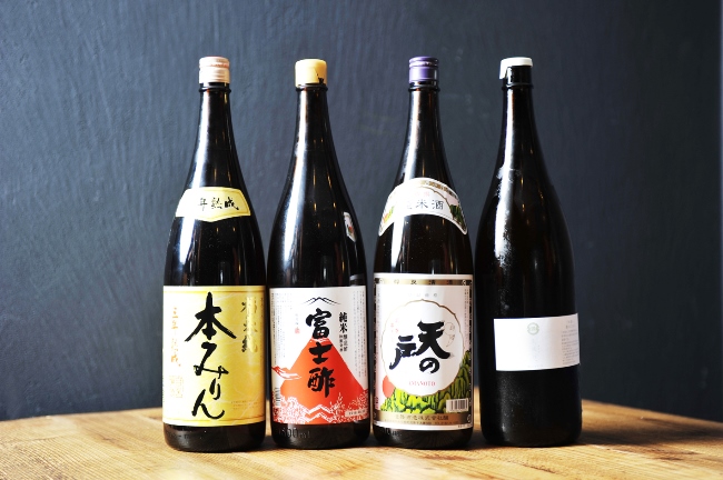 Umebachee!の料理に使われている調味料がこちら。左から岐阜・白扇酒造の「福来純 三年熟成本みりん」、京都・飯尾醸造の「富士酢」、料理酒は秋田・浅舞酒造の「天の戸 純米」、福岡・ミツル醤油醸造所の「生成り、」