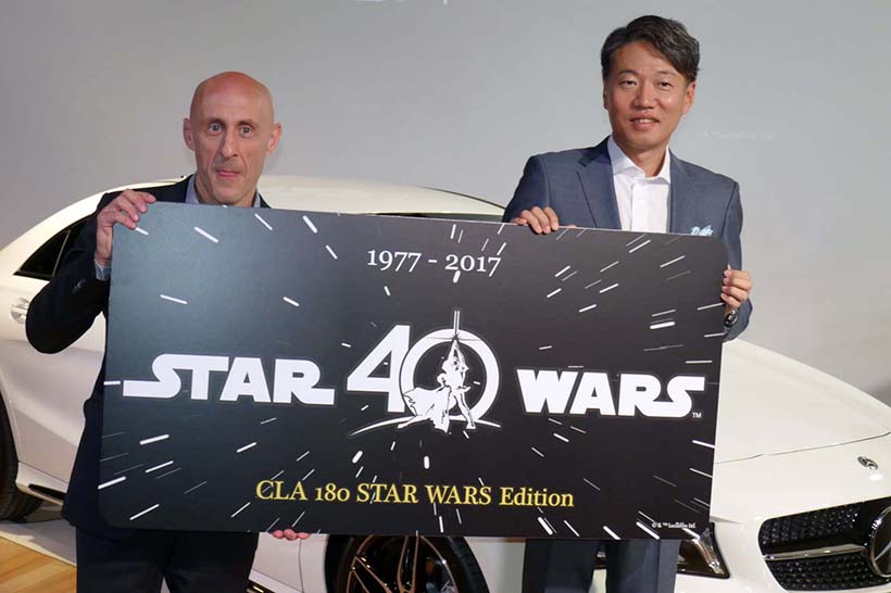 ↑スペシャルコレクターズナンバープレートのイベント用パネルを持つウォルト・ディズニー・ジャパンのゼネラルマネージャー ジャスティン・スカルポーネさん(左)と、メルセデス・ベンツ日本代表取締役社長 上野金太郎さん