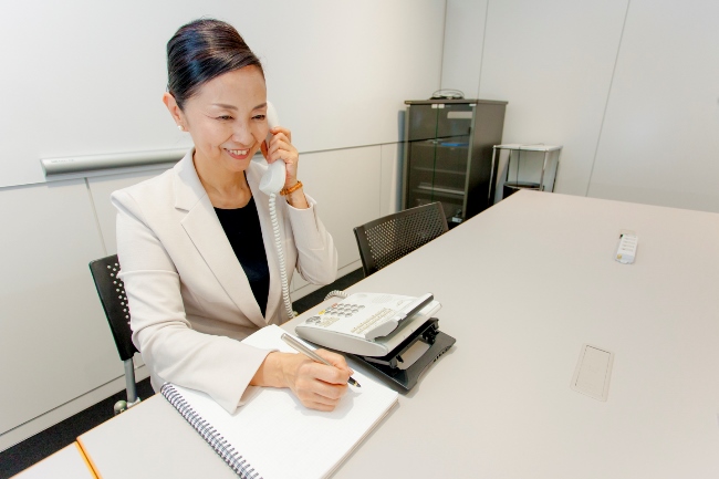 電話応対は背筋を伸ばし、まっすぐ座り、顎を引くと声が安定する。笑顔で明るい声を演出。利き手でメモを取り、反対の手で受話器を持つ。受話器は口から2、3センチほど離す