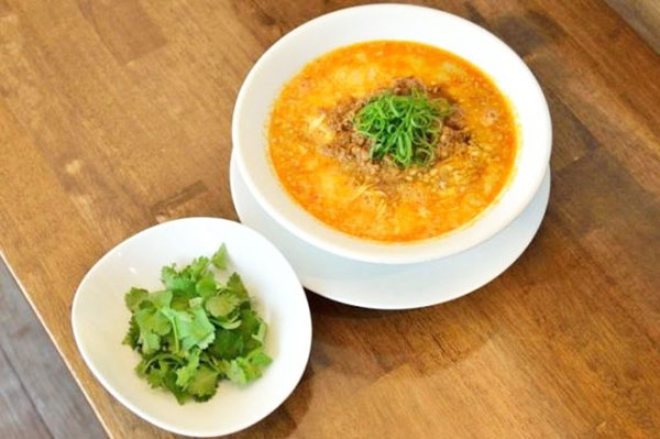 ↑「創作麺工房 鳴龍」で提供されている担担麺(850円)。手前にあるのはパクチー盛(100円)