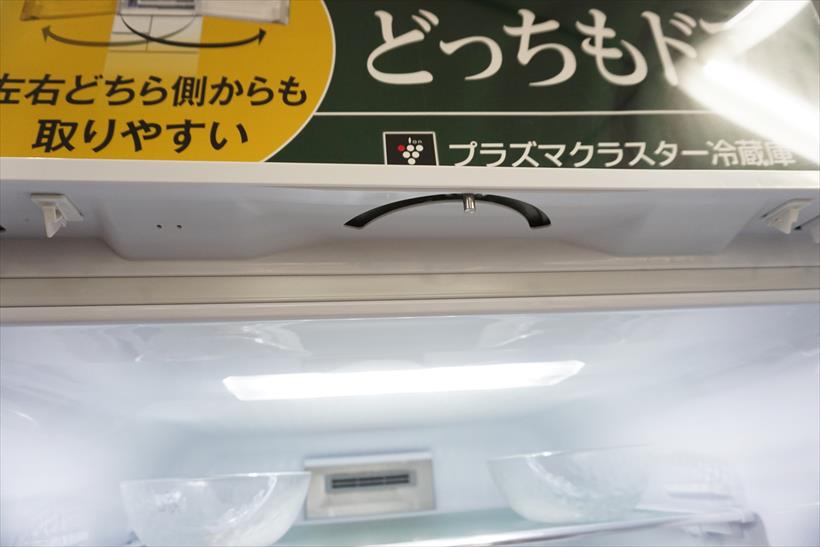 ↑ドア上部に内蔵する電動式の回転機構を下から見たところ。この溝に沿って電動ピンが回転することでドアをゆっくりと開き、閉じるときにも回転して閉じ忘れを防止します