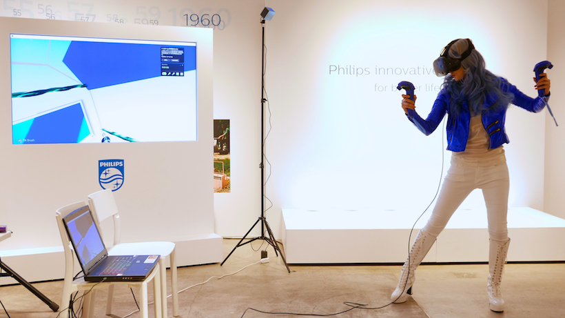 ↑VRアーティスト・せきぐちあいみ氏。両手のコントローラーを自在に操りながら、ディスプレイの中にフューチャリスティックな空間を創出していく