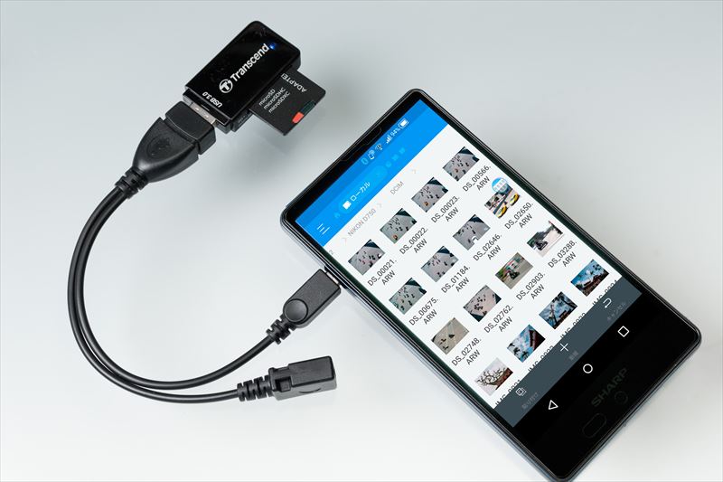 ↑Wi-Fi非搭載のカメラの場合や、RAWファイルを転送したい場合には、スマホにカードリーダーを接続し、「ESファイルエクスプローラー」などのファイル管理ソフトを使って転送するのが便利だ。またUSBホスト(OTG)機能に対応していないスマホの場合は、無線接続のカードリーダーを使う手がある
