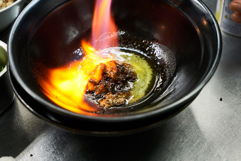 ↑これが「麺家うえだ」の代名詞といえる、“焦がし”のラーメン。牛脂のミンチをベースにした甘味のあるオイルにニンニクなどを効かせ、炎上するほど豪快に炙る。演出だけではなく、香ばしい風味付けとしてもこの所作は欠かせない。スモーキーで、なんとも「Rock」な味わいが生まれる