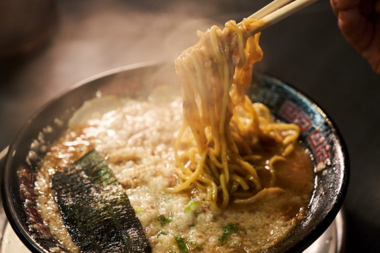 ↑ジュレのようなスープをしっかり絡めて持ち上げる麺は約130g。大盛や替玉は150円となり、替玉の場合は自家製のストレート細麺を選ぶこともできる