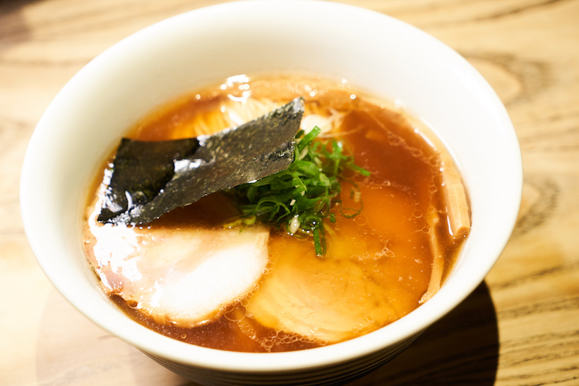↑「醤油らぁ麺」930円(「ミニ醤油らぁ麺」は570円)。山水地鶏や名古屋コーチンなど数種の地鶏に、多彩な魚介のダシを掛け合わせたスープ。そこに北海道産小麦「春よ恋」主体の、トゥルンとした舌ざわりの自家製細麺を使用