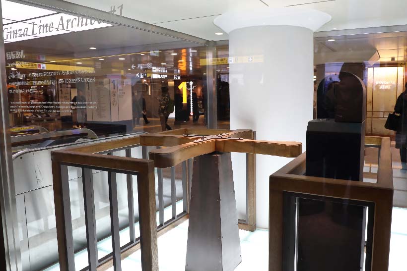 ↑上野駅の改札口横には開業時に使われた木製の回転式改札口(レプリカ)が展示されている。木製バーを身体で押しつつ改札機にコインを投下して入場した