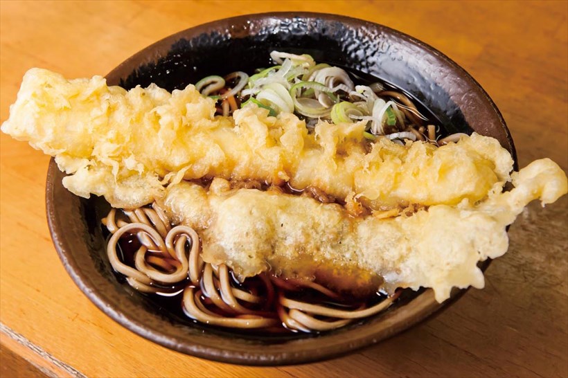 ↑いか天そば(430円)。丼からはみ出す大迫力のいか天。黒いつゆがしみた羽根も文句なし!
