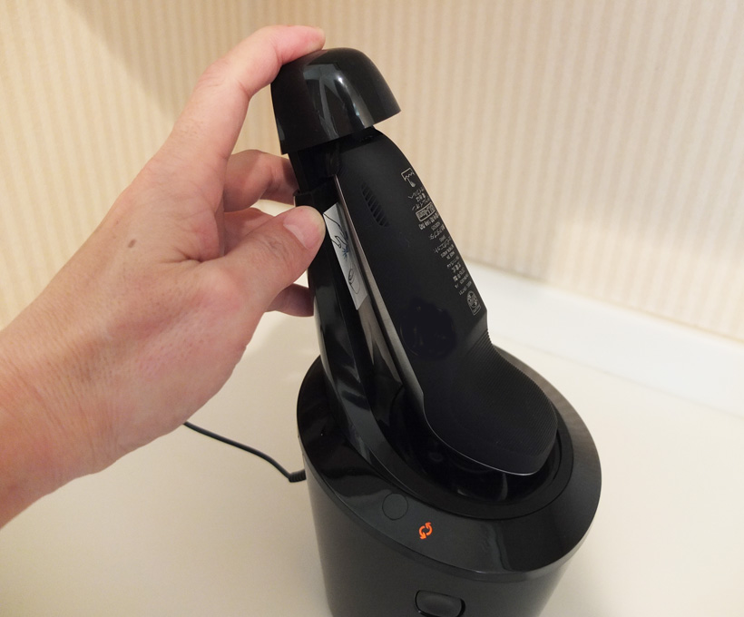 ↑本体が後ろ向きになるようにセット。上部キャップを押し下げてシェーバーをロックすると充電モードに入ります。その後、洗浄充電器のON/OFFスイッチを押すと洗浄を開始します