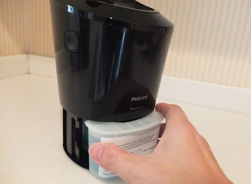 ↑洗浄充電器側面の着脱ボタンを押して本体を上部に上げ、クリーニングカートリッジを前面から装着します