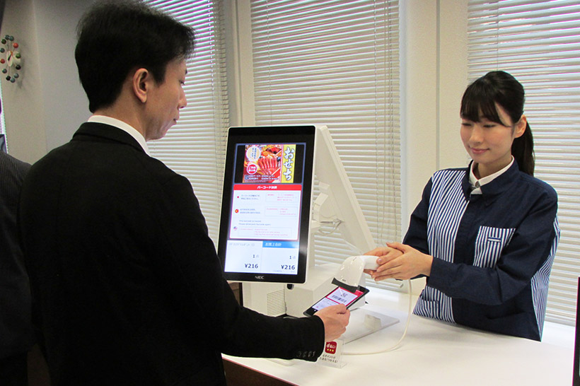 ↑POSレジの場合。ユーザーがスマホで「d払いアプリ」を起動し、店員がバーコードスキャナでその画面のバーコードを読み取る
