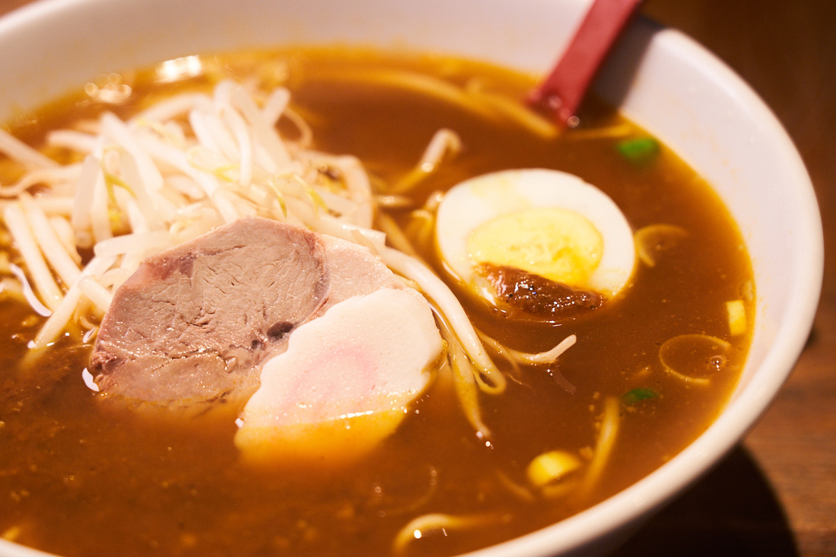 ↑「カレーラーメン」850円。アクセントとして、モヤシや茹で玉子がのる。基本的にはベースの醤油ラーメンにカレーをかけるスタイルだが、食べ進めるうちに混ざり合い、味が変化していくところも面白い