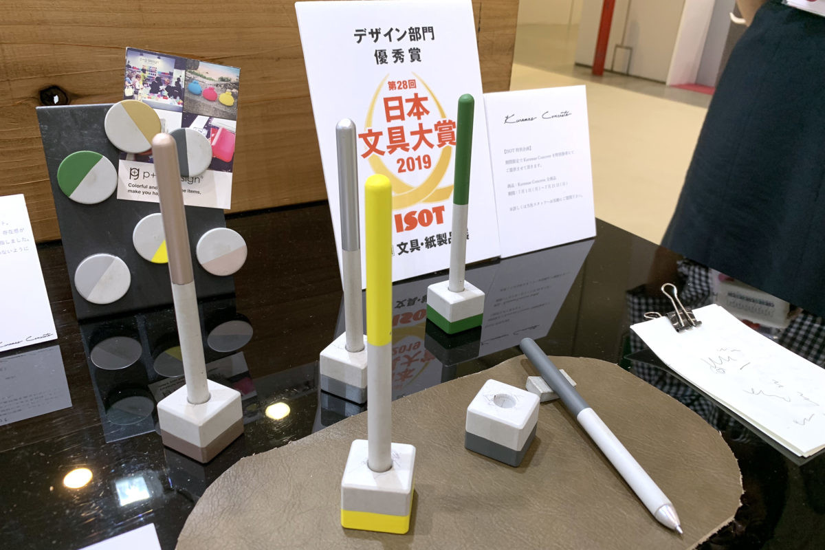 ↑デザイン部門優秀賞のピージーデザイン「Kuramae Concrete Pen」。専用ペンスタンドも付属する