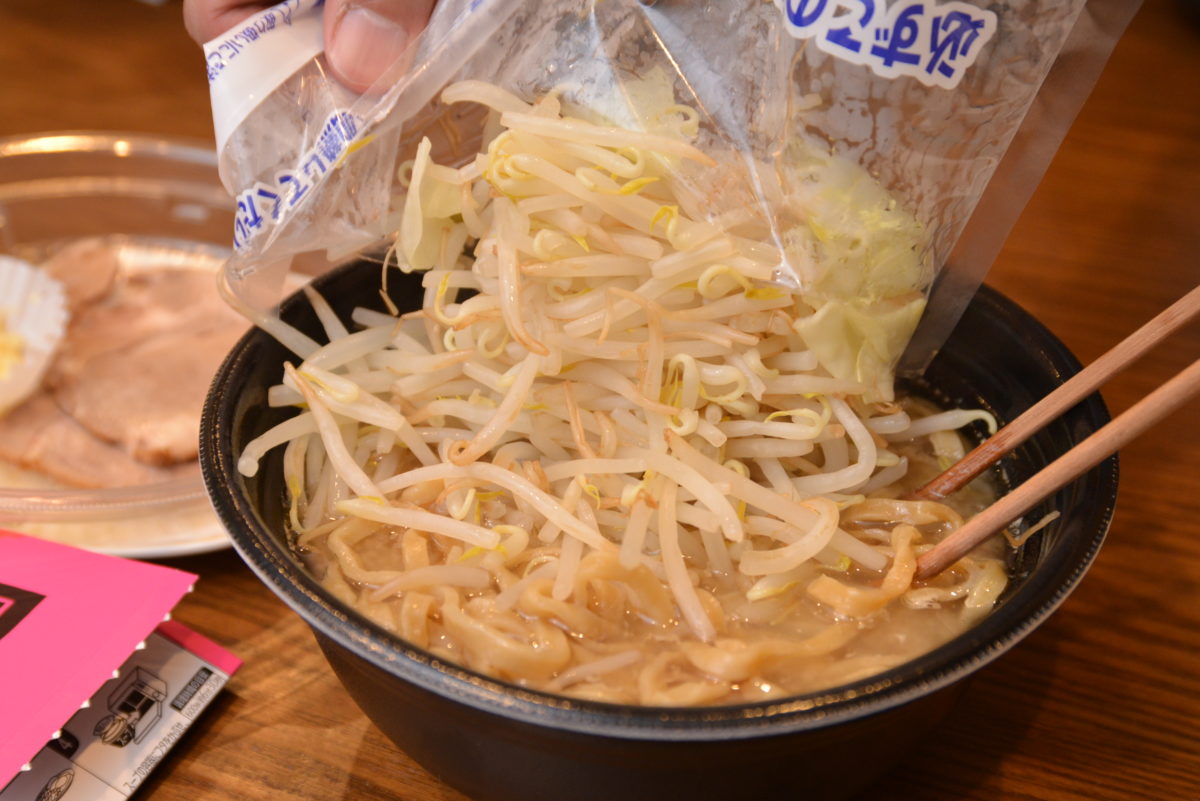 ↑麺をスープに入れ、野菜を盛り付ける。内容は多くがモヤシで、キャベツは少量だった