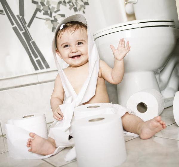 42173008 - a toddler ripping up toilet paper in bathroom