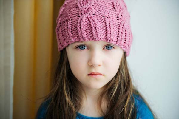 10193689 - close-up portrait of a child girl wearing pink knitted hat